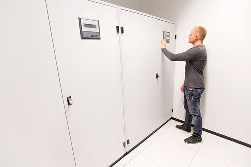 IT engineer adjusts air conditioner in datacenter