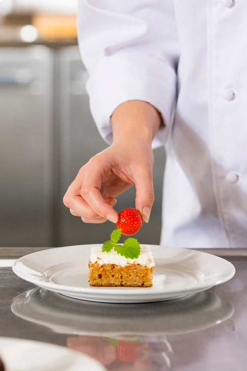Chef decorate dessert cake with strawberry