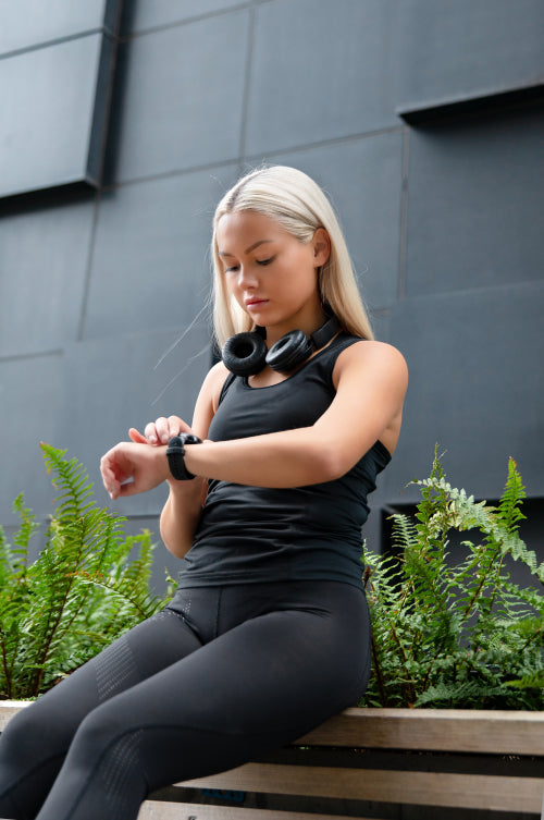 Woman Checks Workout Performance On Smart Watch in City