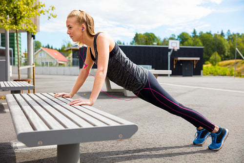 Woman Doing Pushups On Bench In Park