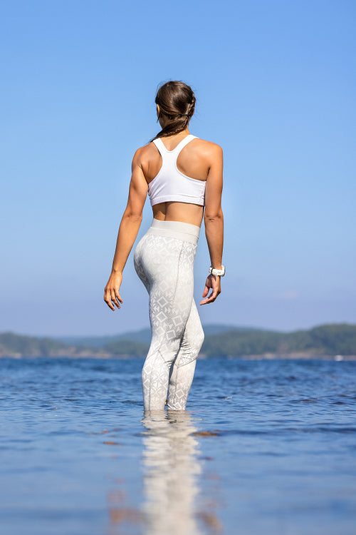 Athletic Woman Standing In Sea Against Clear Sky