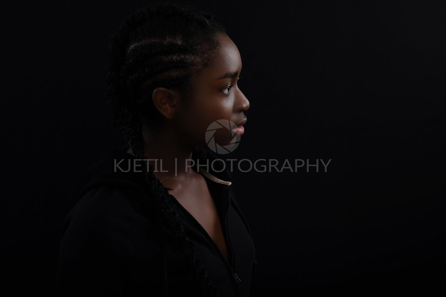 Natural and Beautiful Black Female Model Looking Away Against Black Background