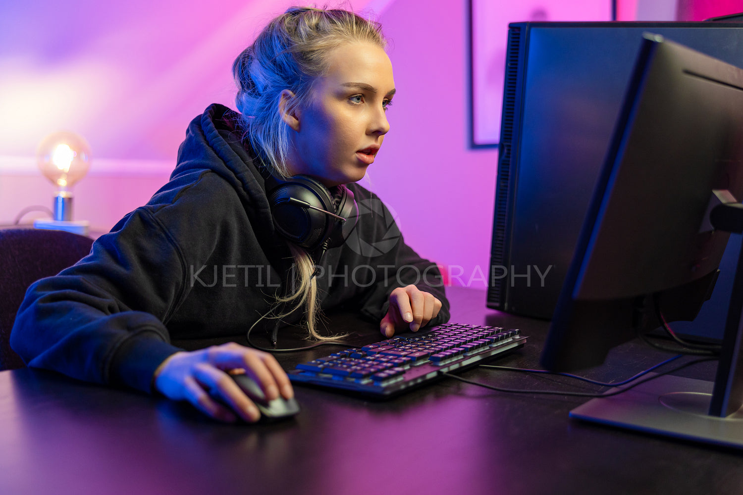 Focused Professional E-sport Gamer Girl in Hoody Playing Online Video Game on PC