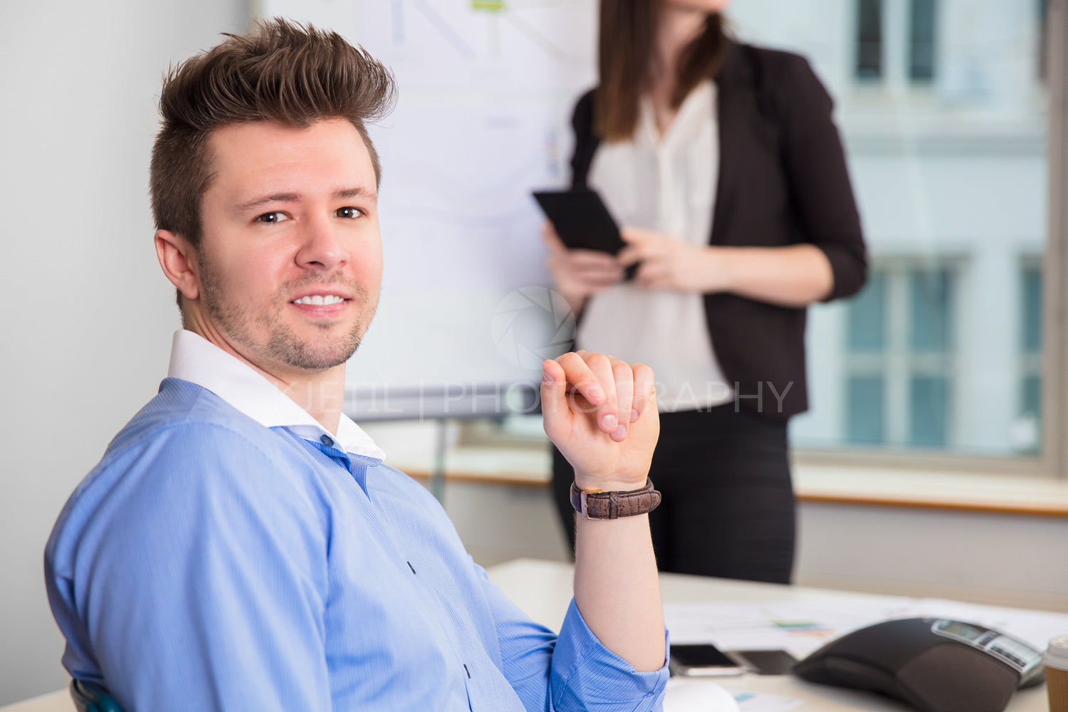 Confident Businessman Smiling While Colleague Standing At Office