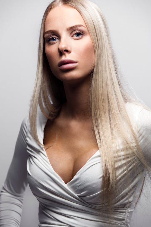 Fashion portrait of a confident blonde woman in white dress