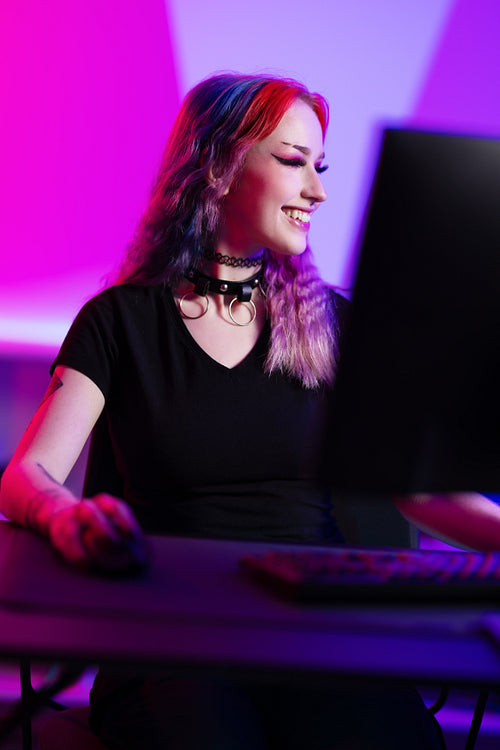 Professional smiling esport gamer girl live streaming and plays online video game on computer