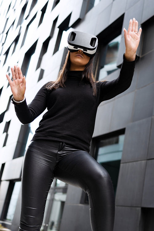 Excited Young Woman Gesturing With Virtual Reality Glasses In Futuristic City