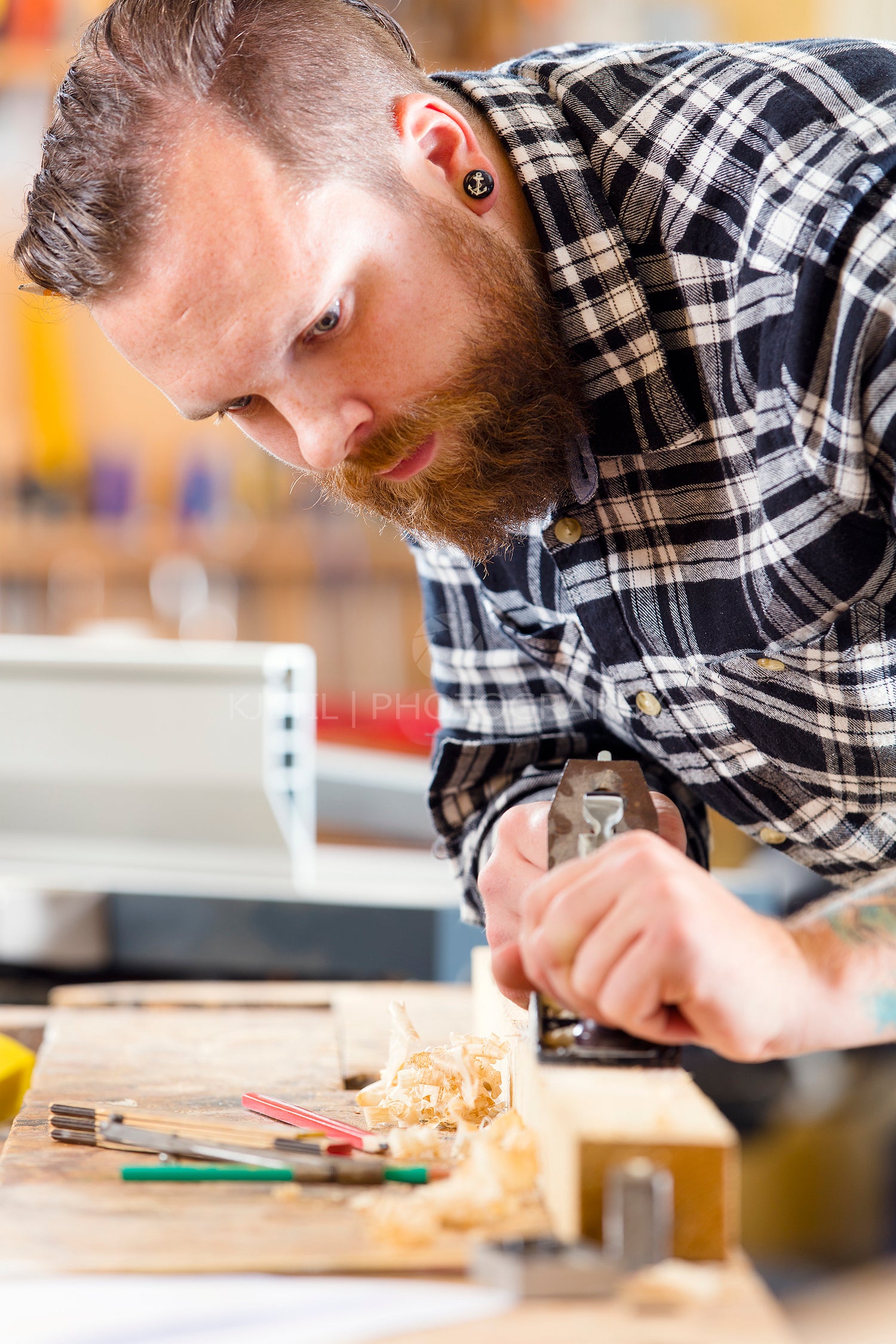 Carpenter work with planer on wood plank in workshop