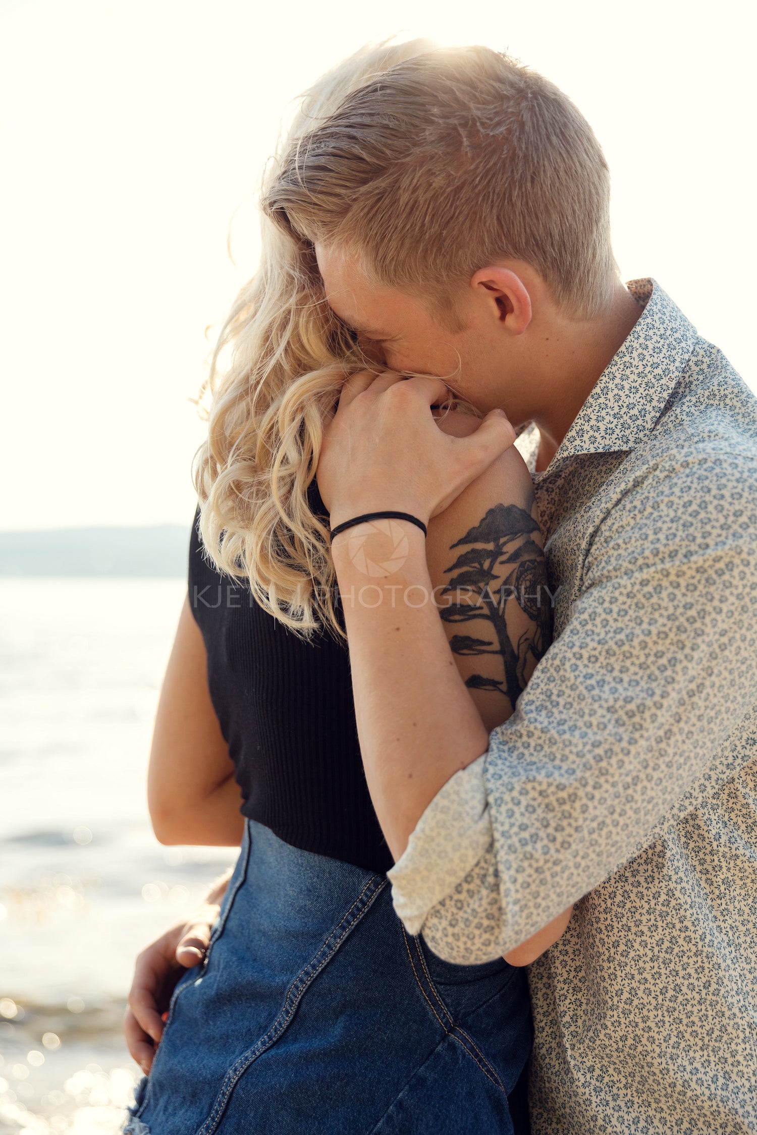 Young Man Embracing Emotional Girlfriend At Beach