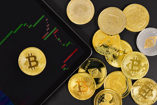 Bitcoin on digital tablet with graph by coins
