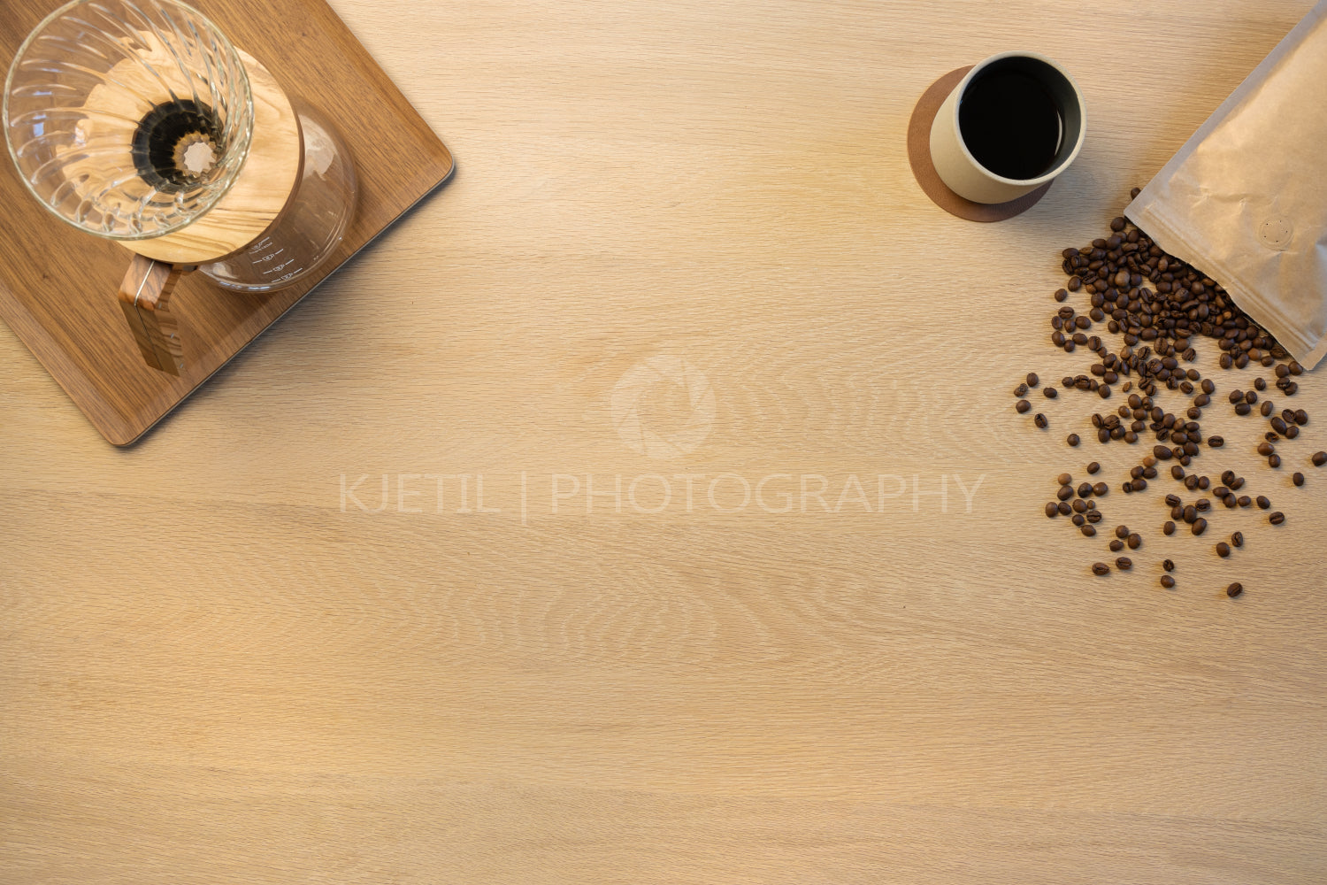 Overhead view of coffee beans with cup and filtration containers on table
