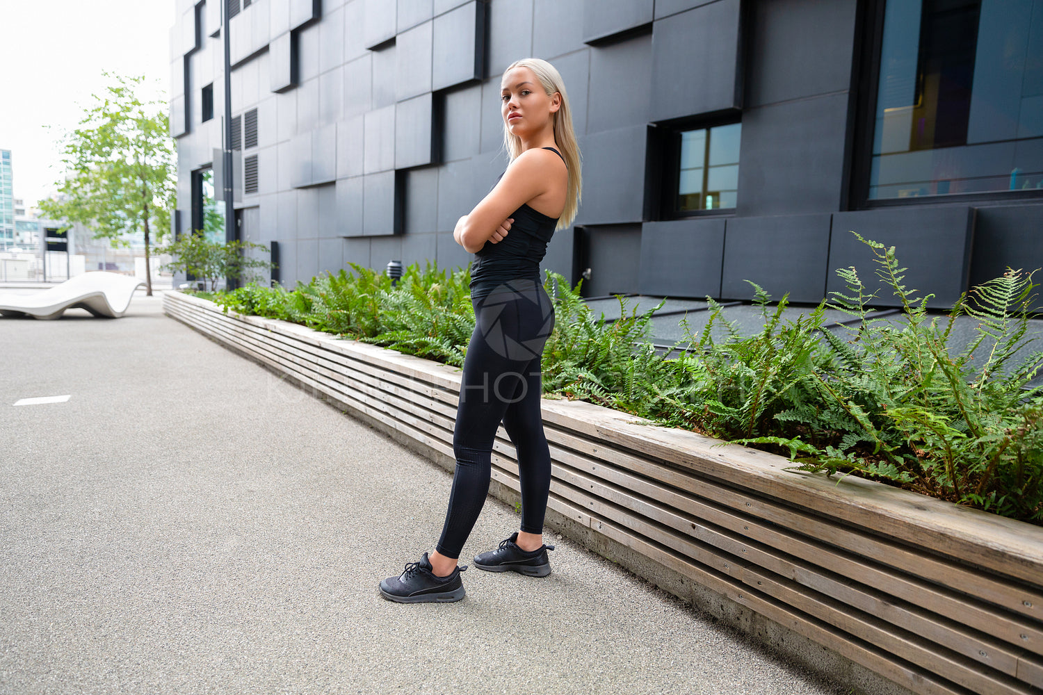 Confident Female Urban Runner Standing With Her Arms Crossed