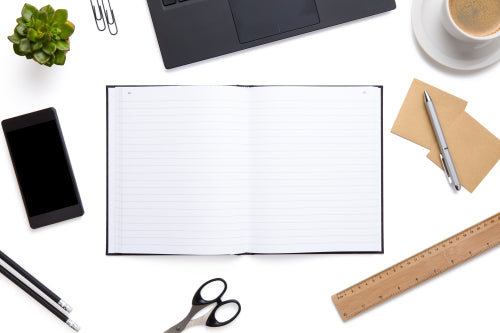 Open Diary Surrounded With Office Supplies On Isolated White Background