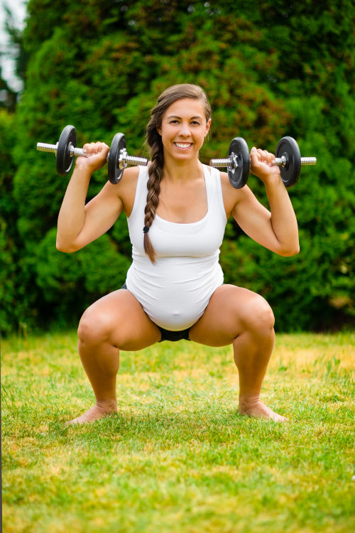 Pregnant Woman Doing Squat Press Using Weights In Park