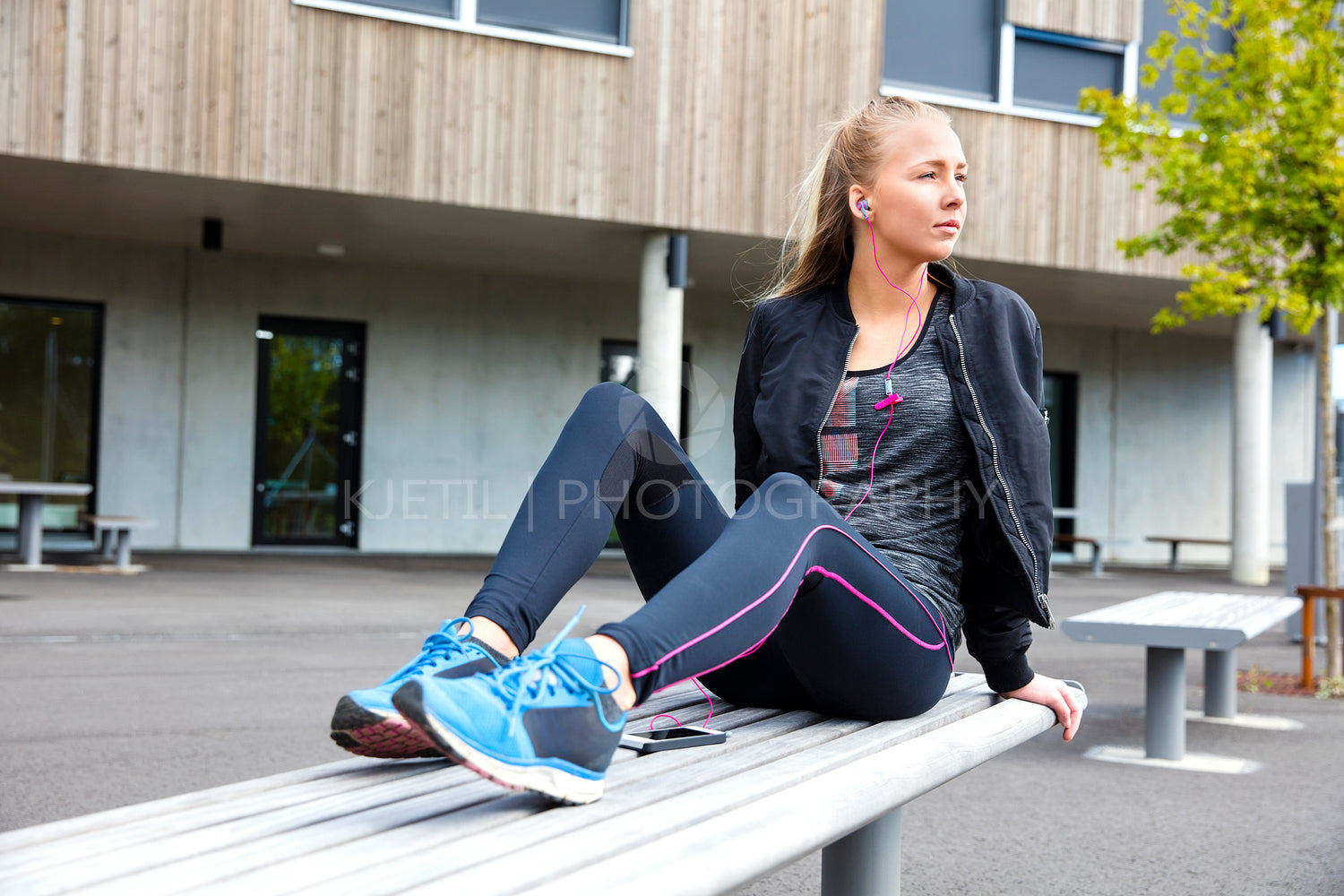 Sporty Woman Listening To Music While Sitting On Bench