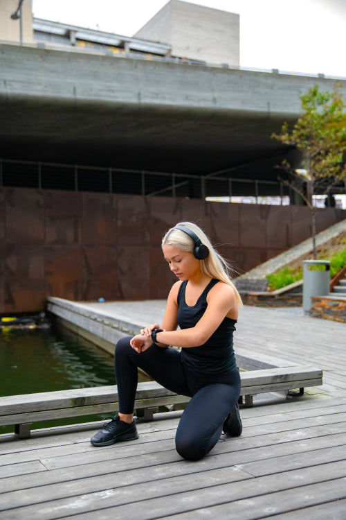 Sporty Woman Listening Music and Using Smartwatch Before Running
