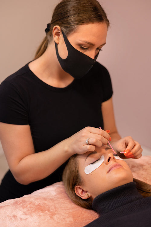 Female Cosmetologist Treating Customer For Eyelash Extension