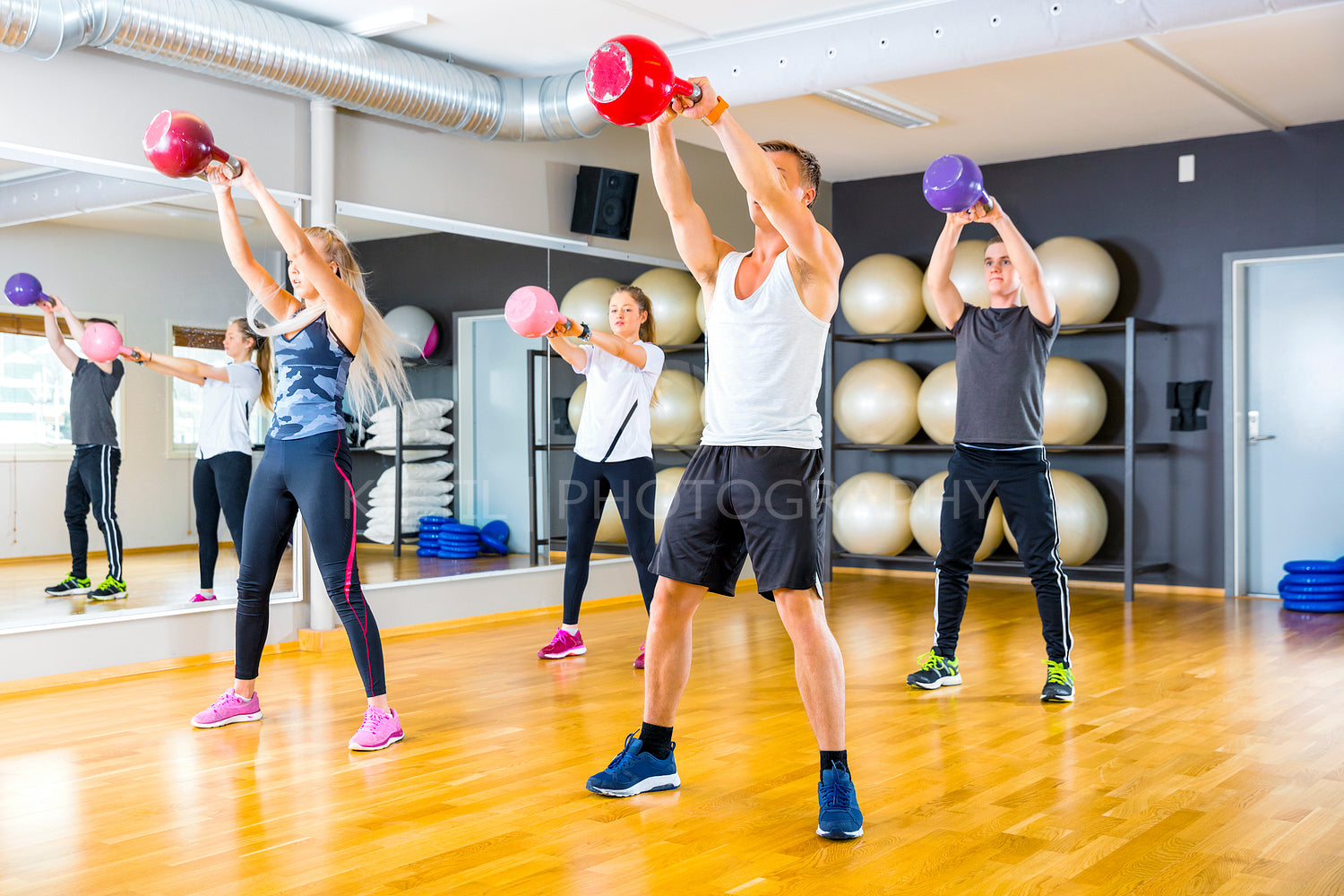Focused team trains with kettlebells at fitness gym