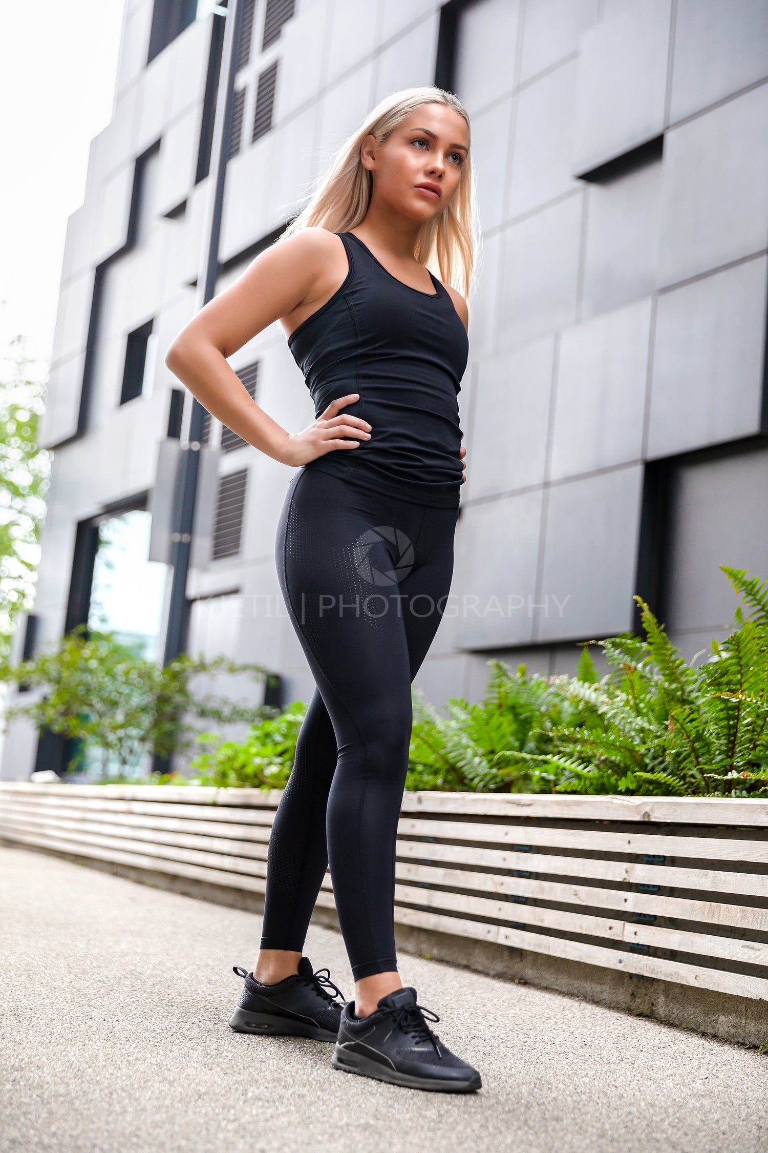 Confident Attractive Athletic Woman Standing Against Building In City