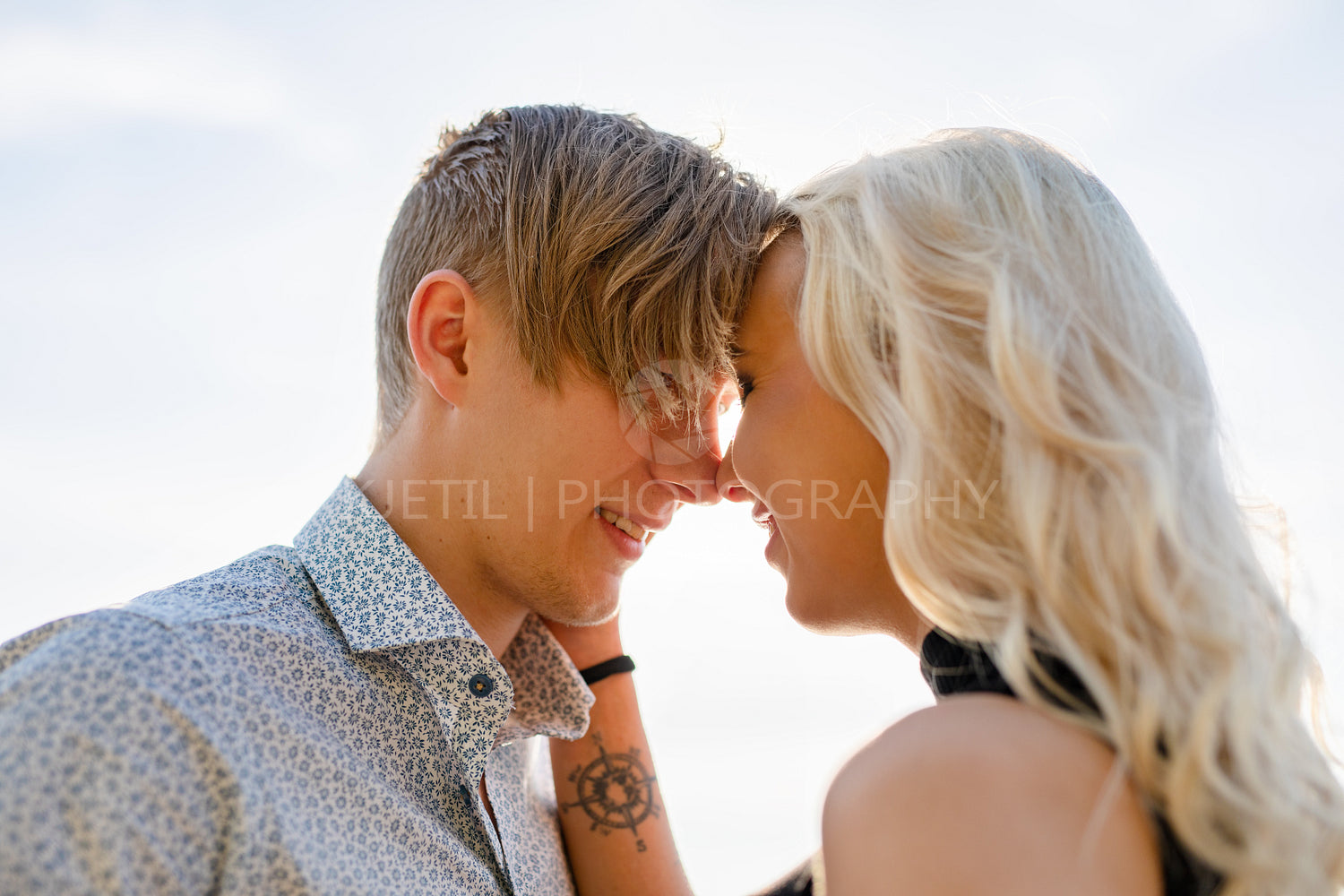 Flirting couple in romantic embrace on beach at summer