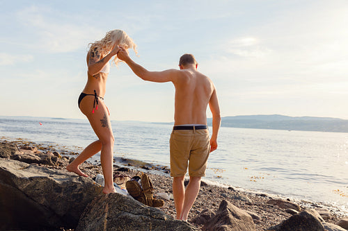 Romantic Man Holding Hand Helping Girlfriend On Rocks