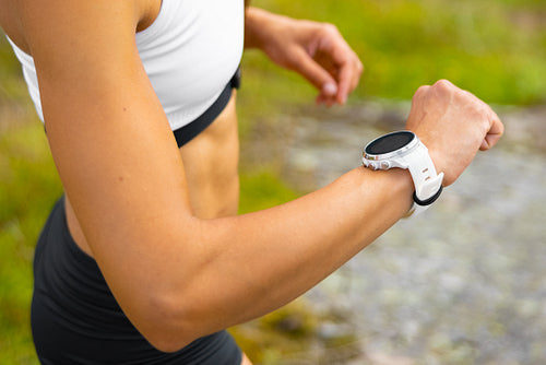 Close-up of athletic woman using fitness smart watch device under workout