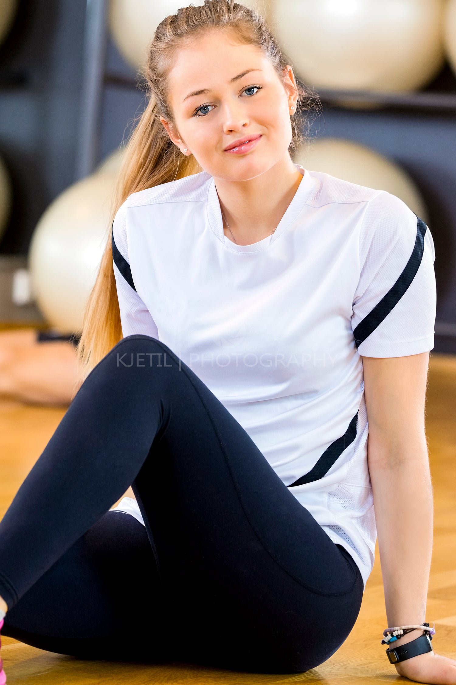 Smiling young woman in workout outfit at the fitness gym