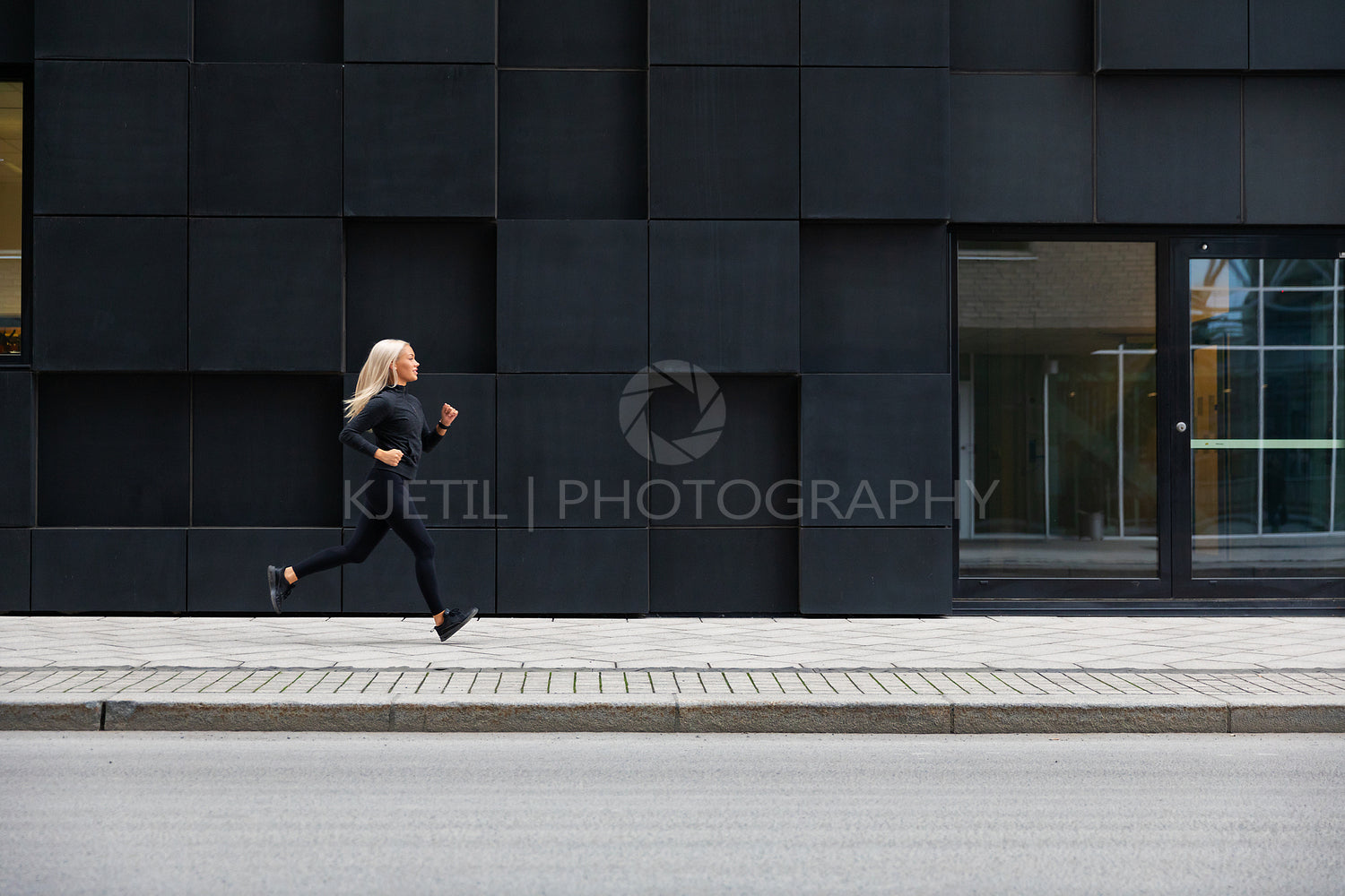 Side view of sporty young woman runner in minimalist urban environment