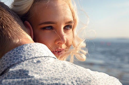 Portrait Of Young Woman Embracing Boyfriend At Beach