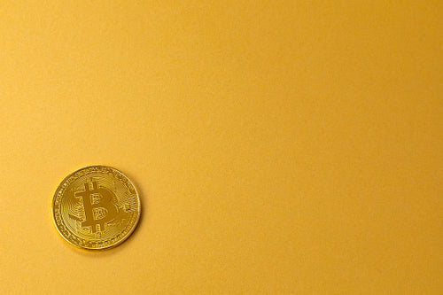 Gold bitcoin crypto currency coin on gold yellow backgound