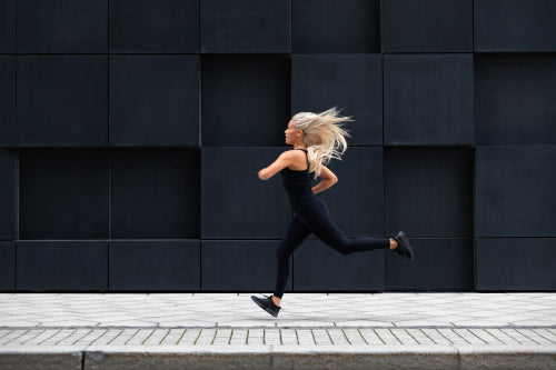 Fit young woman running in minimalist urban city environment