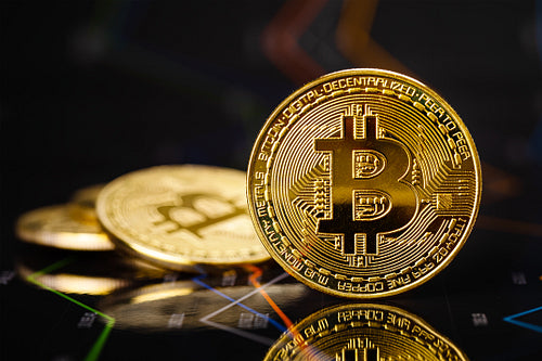 Gold bitcoin standing on financial charts for cryptocurrency prices
