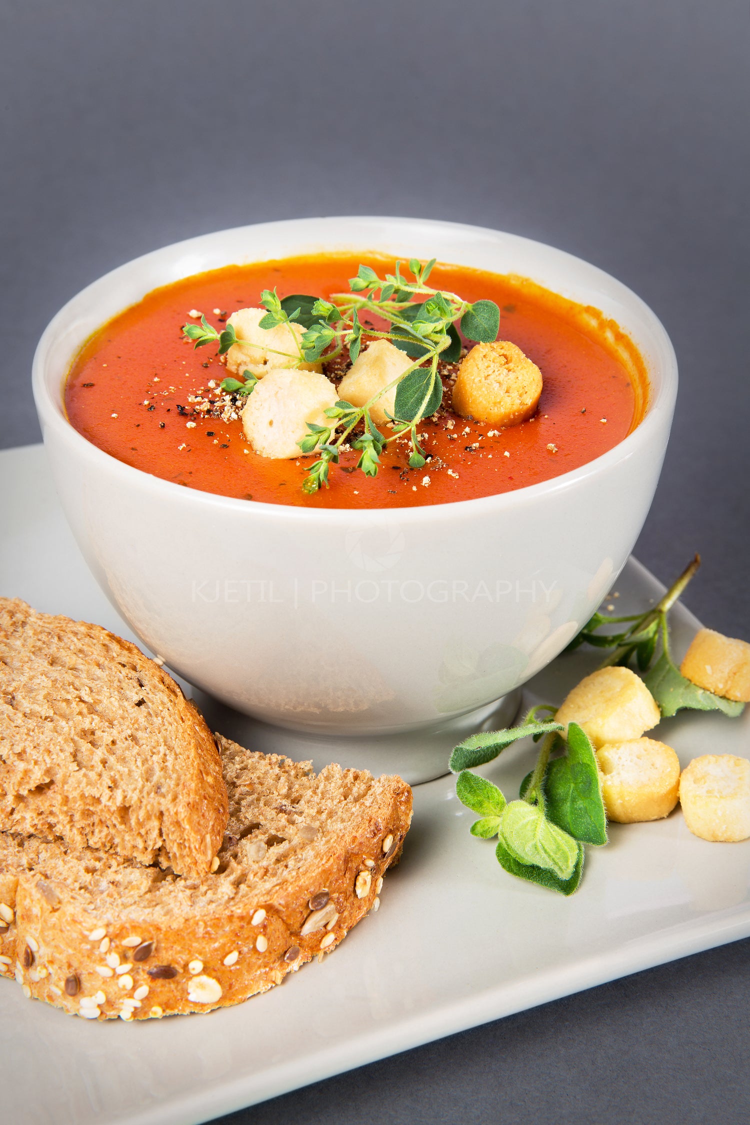 A bowl with Tomato Soup with Croutons and Herbs