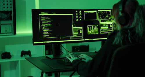 Cyber security hacker code harmful software to exploit vulnerability in program or system in dark room