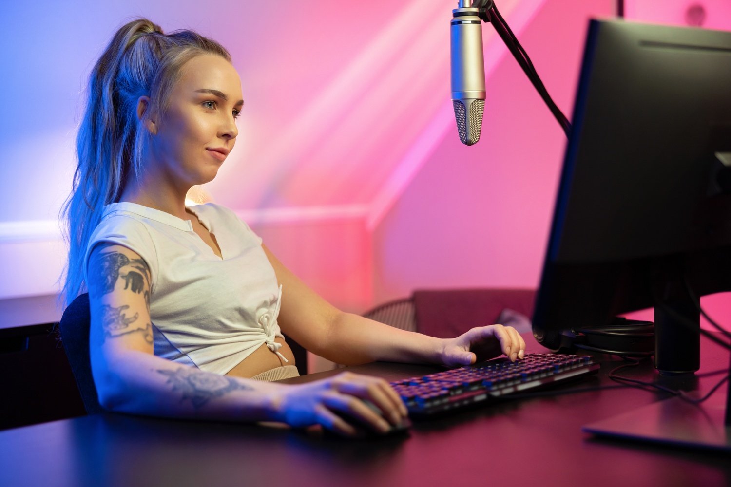 Good looking professional gamer girl streams and play online multiplayer video game on PC