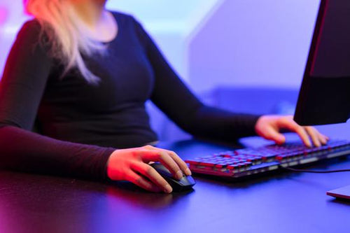 Close-up of Blonde Gamer Girl Playing Online Video Game on Her Personal Computer.